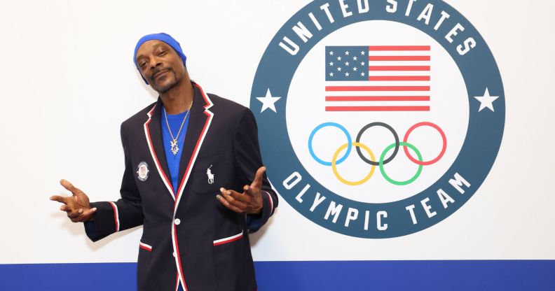 Snoop Dogg standing in front of a sign that says 'United States Olympic Team'