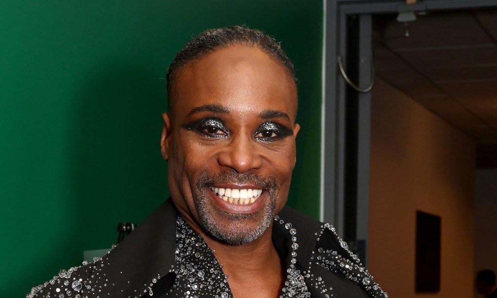 Billy Porter poses in a shiny sequin shirt with a glittery grey smoky eyeshadow