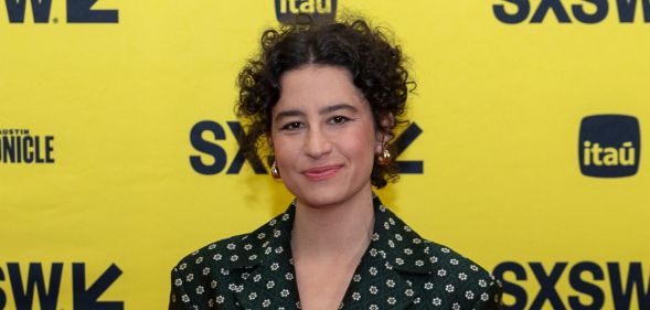 Ilana Glazer in a spotted dress against a yellow background