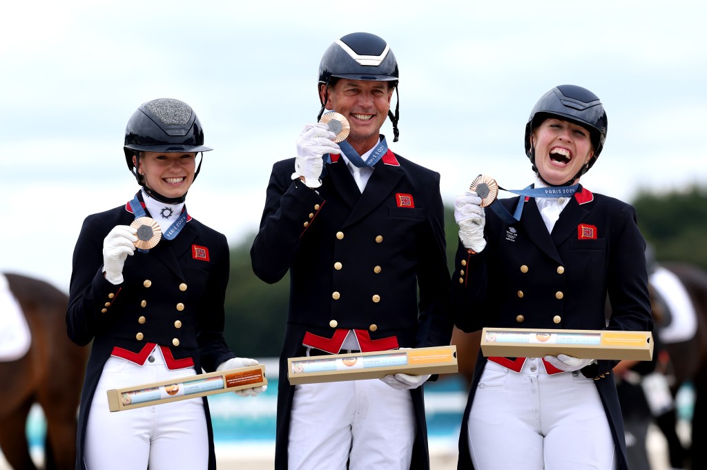 Bronze medalists Charlotte Fry, Carl Hester and Becky Moody of Team Great Britain pose for a photo during the medal ceremony for the Dressage Team Grand Prix Special