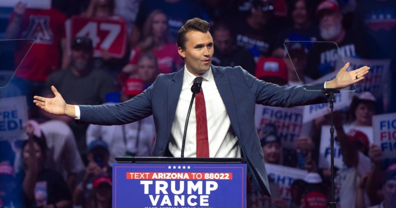 Turning Point USA Founder Charlie Kirk speaks during a campaign rally for Republican presidential nominee, former U.S. President Donald Trump, standing at the podium with his arms open