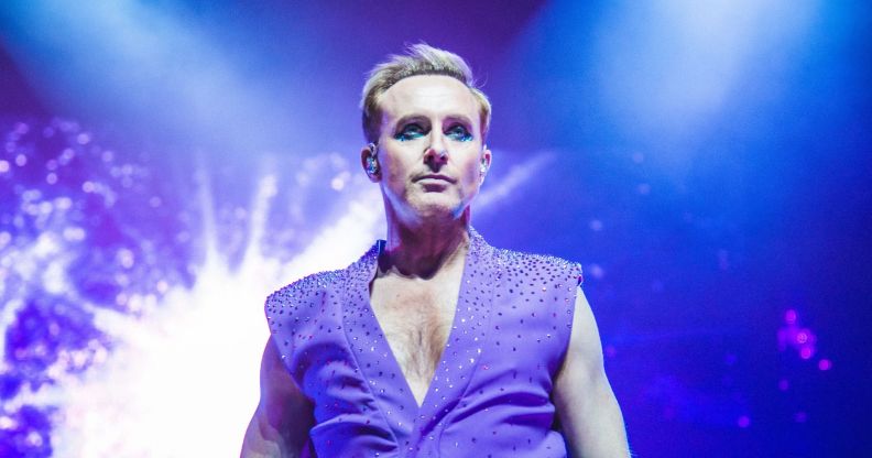 Ian H Watkins performing in a sleeveless purple waistcoat