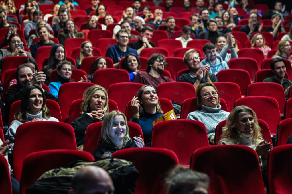 People enjoy popcorn as they watch a live screening