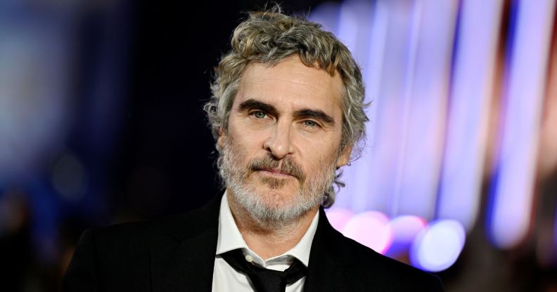 Joaquin Phoenix in a black suit and tie