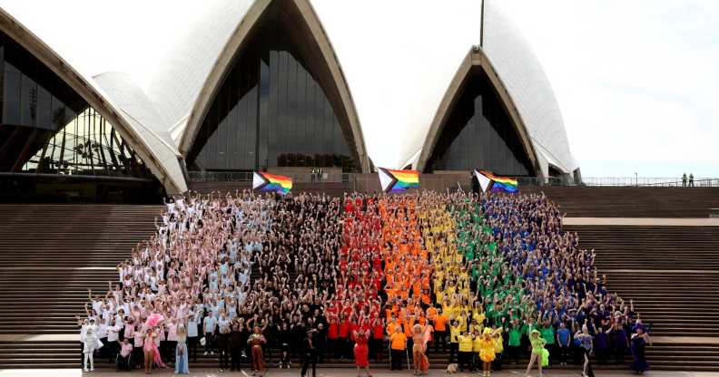 SYDNEY, AUSTRALIA - JUNE 24: 1,000 people form a human progress flag on the steps of the Opera House to mark the 44th anniversary or the Sydney Gay and Lesbian Mardis Gras Sydney Opera House on June 24, 2022 in Sydney, Australia. Australia will host WorldPride 2023. (Photo by Don Arnold/Getty Images)