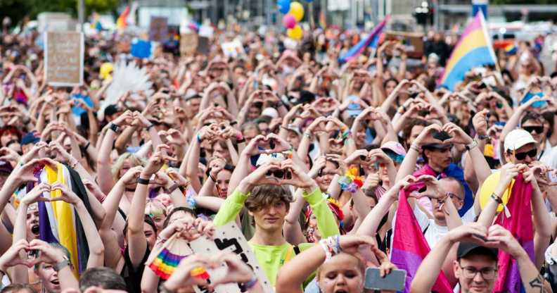 Attendees of Leipzig Pride hold up a heart symbol as they participate in the Pride rally.