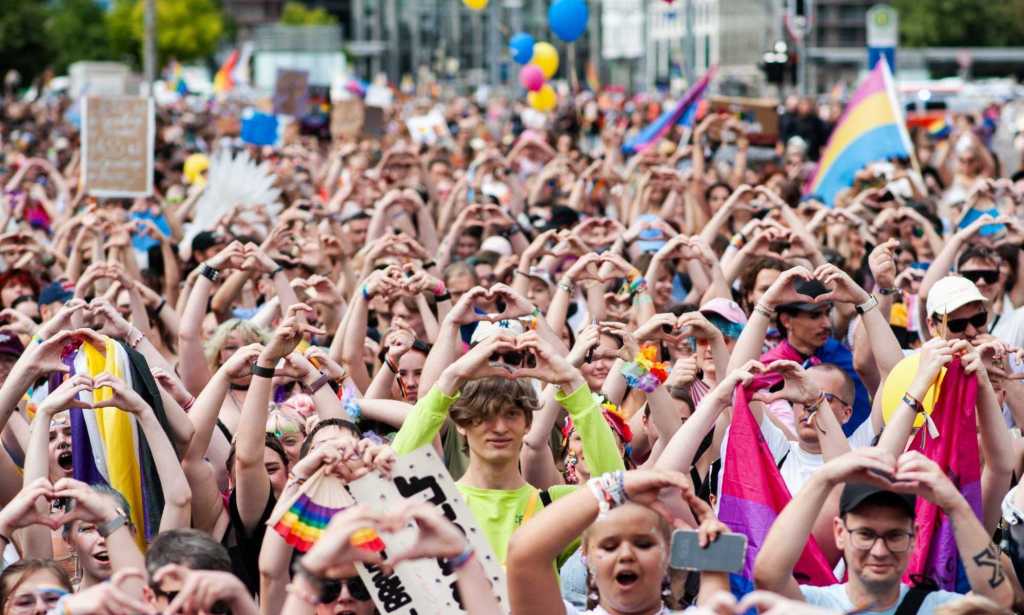 Attendees of Leipzig Pride hold up a heart symbol as they participate in the Pride rally.