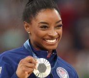 Simone Biles holding up a medal.