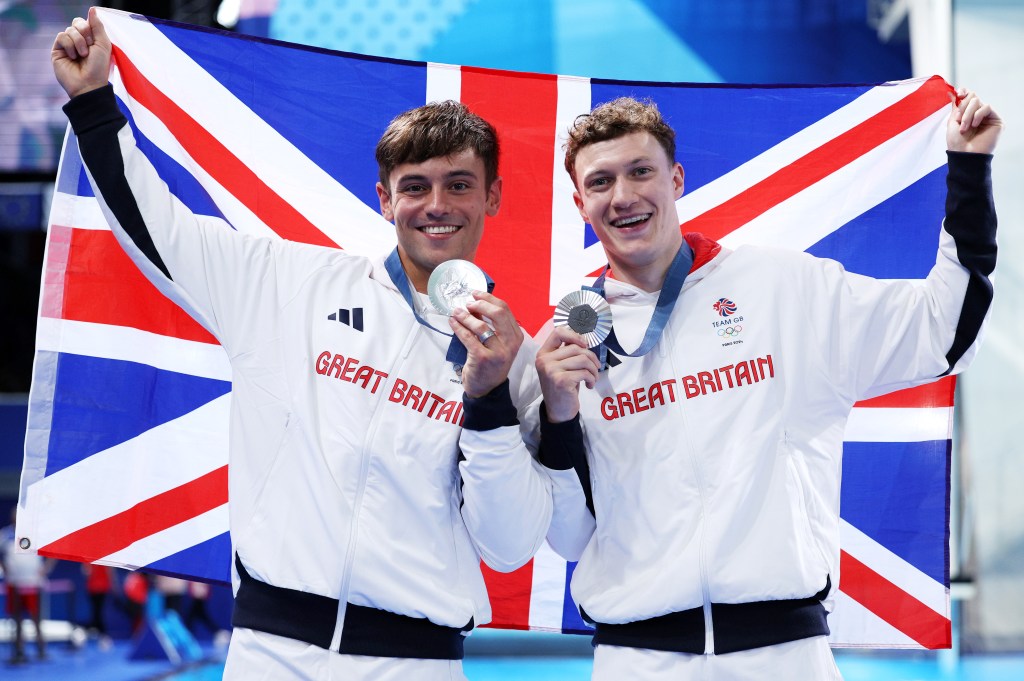 Silver Medalists Thomas Daley and Noah Williams of Team Great Britain pose with the national flag of Team Great Britain