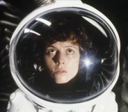 Actors Sigourney Weaver in a space suit looking up.