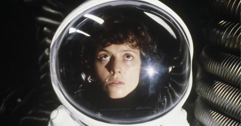 Actors Sigourney Weaver in a space suit looking up.