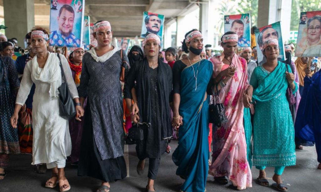 This is an image of six transgender Bangladeshi women in a march. They are all wearing solid colour dresses and head scarves. 