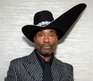 Billy Porter at the 2019 Emmy Awards in a black and silver suit and huge black hat.