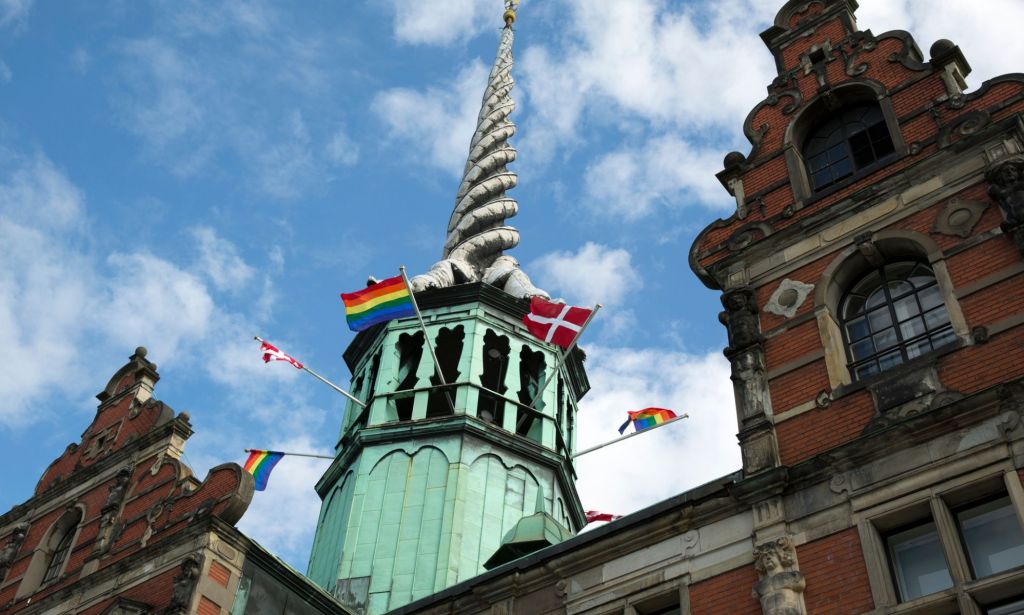 A Pride flag flies along with the Danish flag outside the Børsen, the old stock exchange in Denmark's capitol city of Copenhagen.