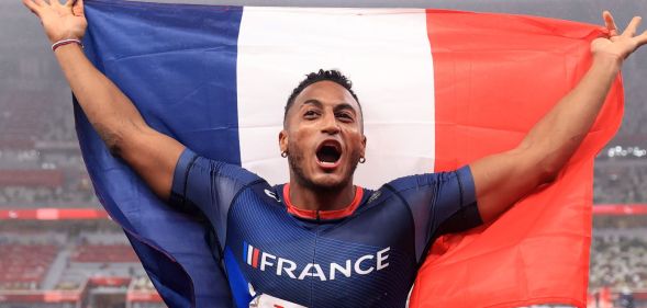 French Paralympic athlete Dimitri Pavadé holds French flag behind him