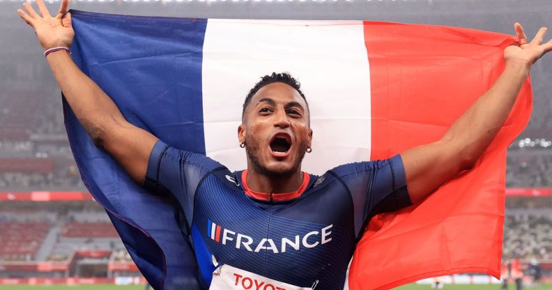 French Paralympic athlete Dimitri Pavadé holds French flag behind him