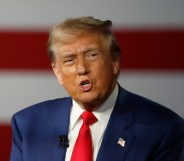 Republican presidential nominee, former U.S. President Donald Trump participates in a Town Hall debate. He's wearing a navy suit with a white shirt.