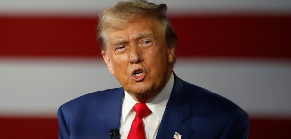 Republican presidential nominee, former U.S. President Donald Trump participates in a Town Hall debate. He's wearing a navy suit with a white shirt.