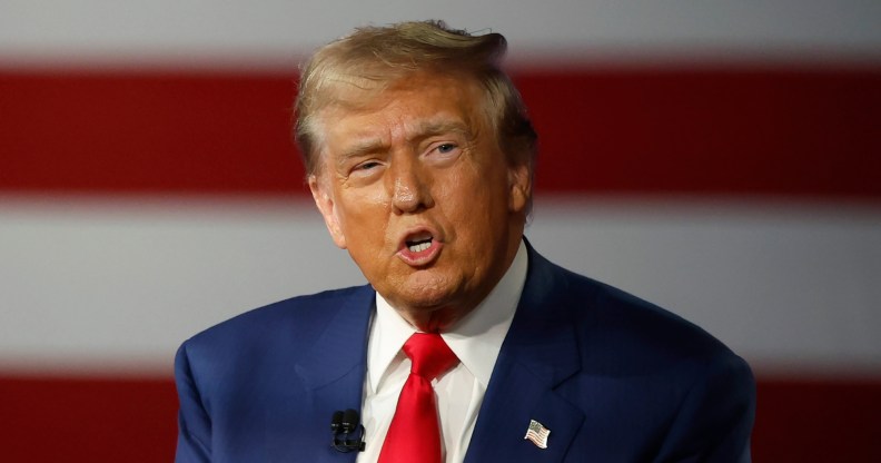 Republican presidential nominee, former U.S. President Donald Trump participates in a Town Hall debate. He's wearing a navy suit with a white shirt.