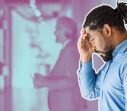 This is an image of a Black man looking frustrated while leaning on a wall. He has short dread locks tied up behind his head. He has a beard and is wearing a blue shirt.