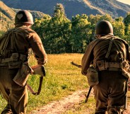 Advancing the battle, two World War II combat Soldiers take off charging across an open field.