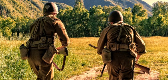 Advancing the battle, two World War II combat Soldiers take off charging across an open field.