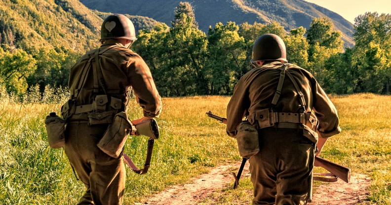 Advancing the battle, two World War II combat Soldiers take off charging across an open field.