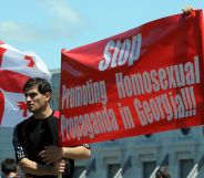 Two men holding up a sign that reads "stop promoting homosexual propaganda in Georgia."