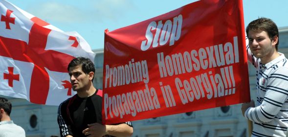 Two men holding up a sign that reads "stop promoting homosexual propaganda in Georgia."