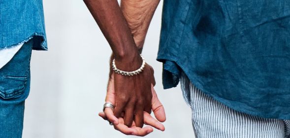 Two men hold hands in public.