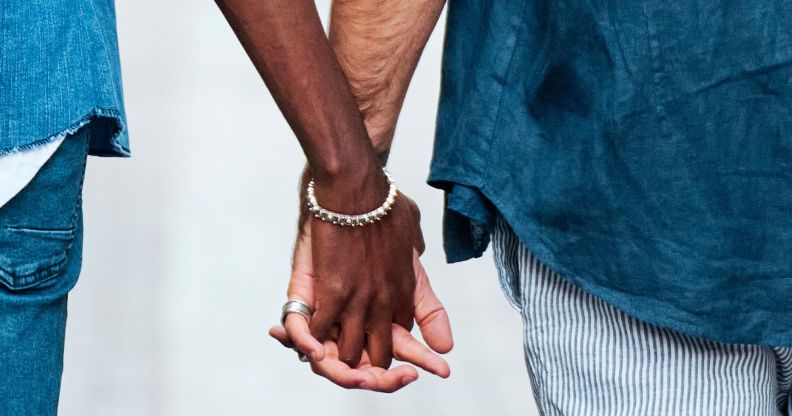 Two men hold hands in public.