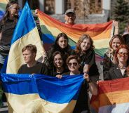 A crowd holding Lesbian, LGBTQ+, and Ukrainian flags.