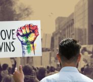 This is an image of someone holding a protest sign that reads "Love Wins" in a protest. The sign is being held by a man with short hair facing away from the camera. The sign is in full colour while the rest of the image is in a sepia tone