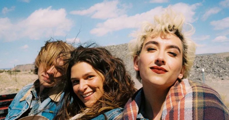 National Anthem still: Charlie Plummer, Eve Lindley, and Mason Alexander Park in the back of a truck wearing denim jackets, their hair blowing in the wind.