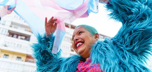 Stock image of a person waving a trans flag