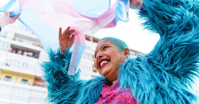 Stock image of a person waving a trans flag