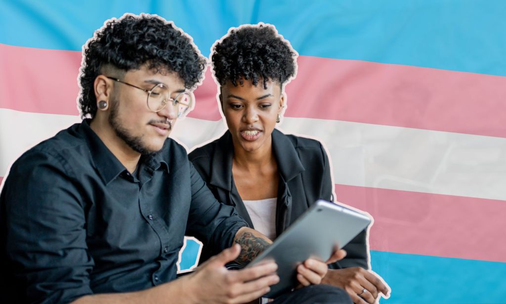 This is an image of a trans masculine person and a Black woman looking down at a tablet. 