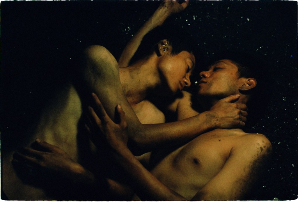 Viêt and Nam still, two people are embracing topless surrounded by darkness