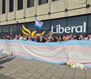 Liberal Democrats party members unfurling giant trans flag outside the Brighton Centre