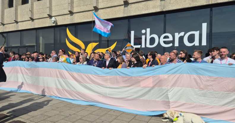 Liberal Democrats party members unfurling giant trans flag outside the Brighton Centre