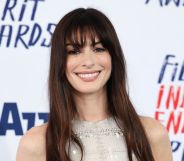 Anne Hathaway smiles on a red carpet in 2024.