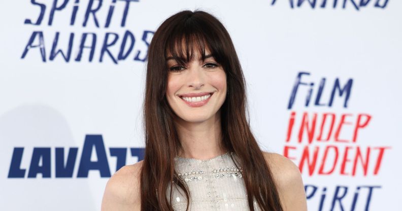 Anne Hathaway smiles on a red carpet in 2024.