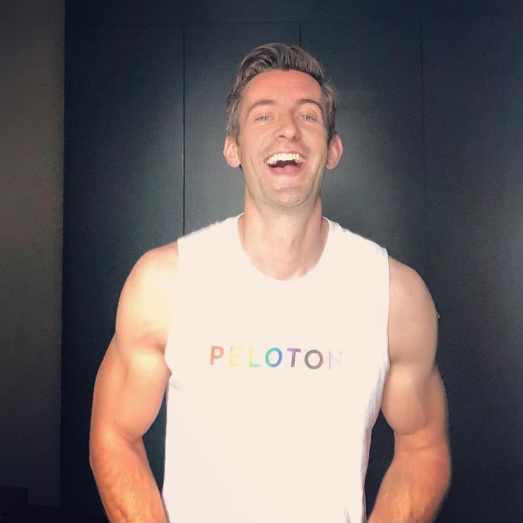 Ben Thompson in a rainbow-lettered white tank top