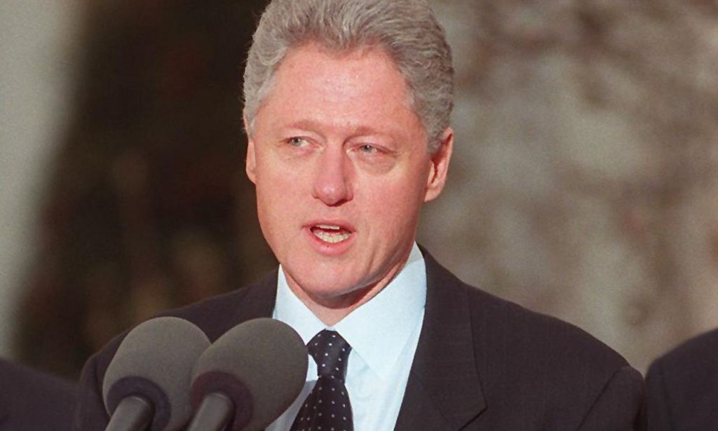 Bill Clinton speaking into a microphone during a speech.