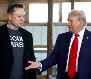 Republican presidential nominee, former President Donald Trump offers his hand to Elon Musk back stage during a campaign rally at the Butler Farm Show grounds on October 05, 2024 in Butler, Pennsylvania