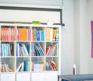 Stock image of a classroom with a Pride flag on the wall.