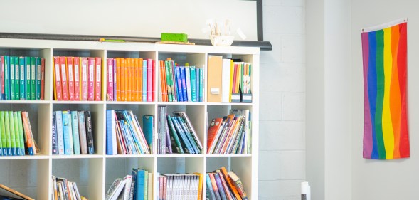 Stock image of a classroom with a Pride flag on the wall.