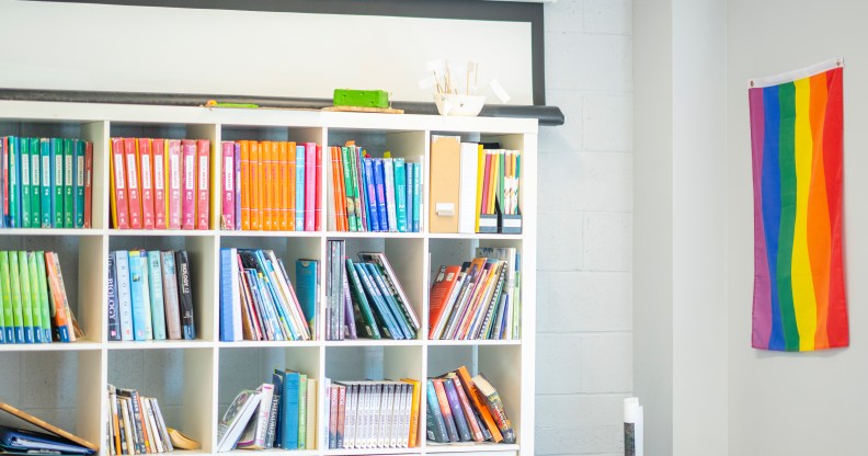 Stock image of a classroom with a Pride flag on the wall.