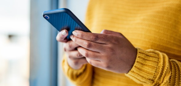 Shot of an unrecognizable woman using a mobile phone indoors