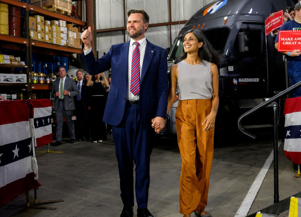 Republican vice presidential nominee, U.S. Sen. J.D. Vance (R-OH) walks on stage with his wife, Usha before speaking at a rally at trucking company